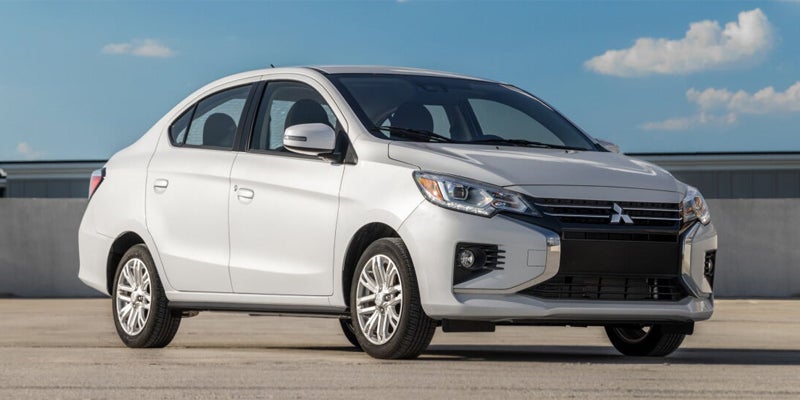 A white 2023 Mitsubishi Mirage G4 parked on a rooftop parking.